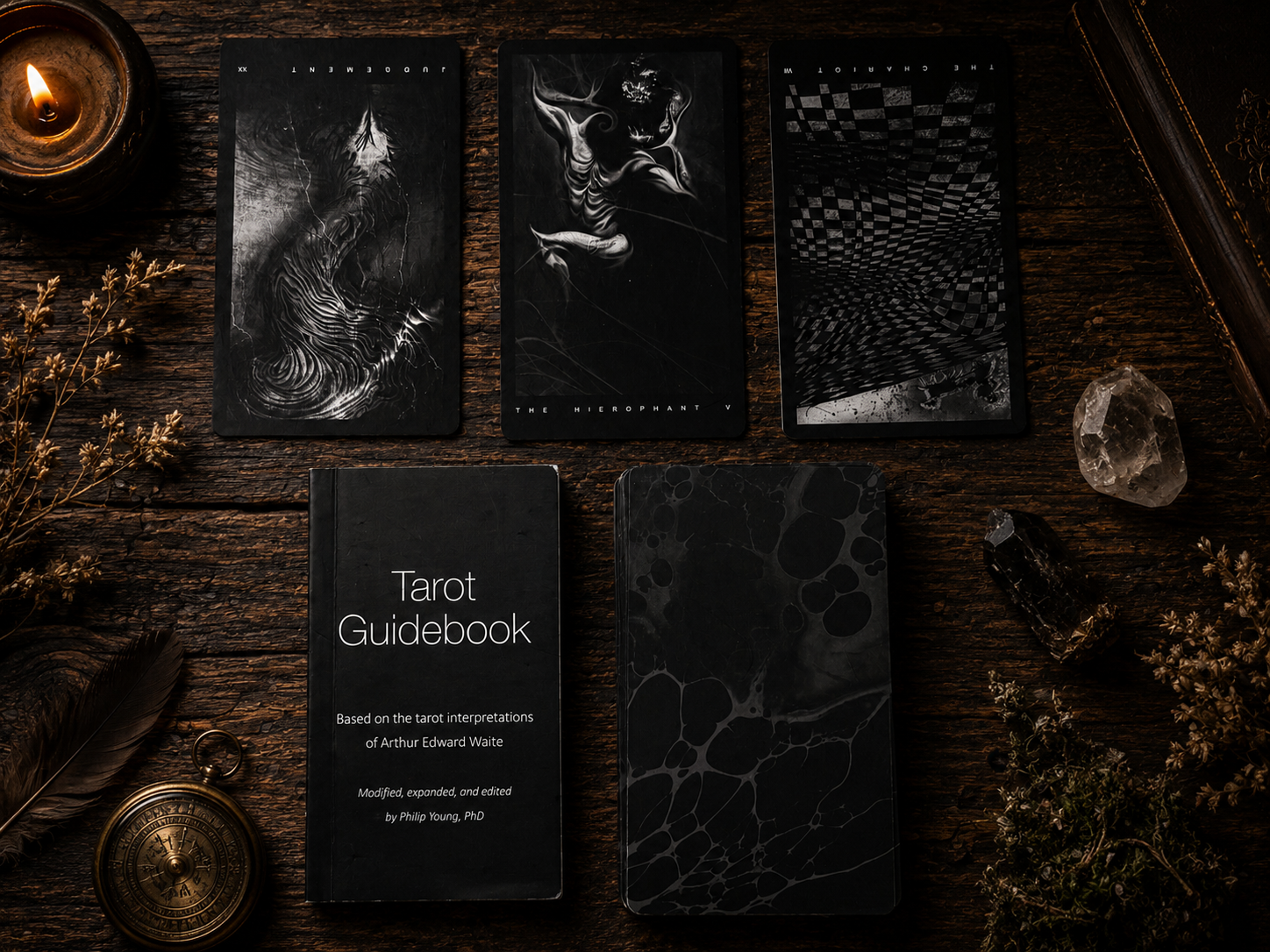 The Black Tarot cards arranged in a dark gothic spread beside the guidebook